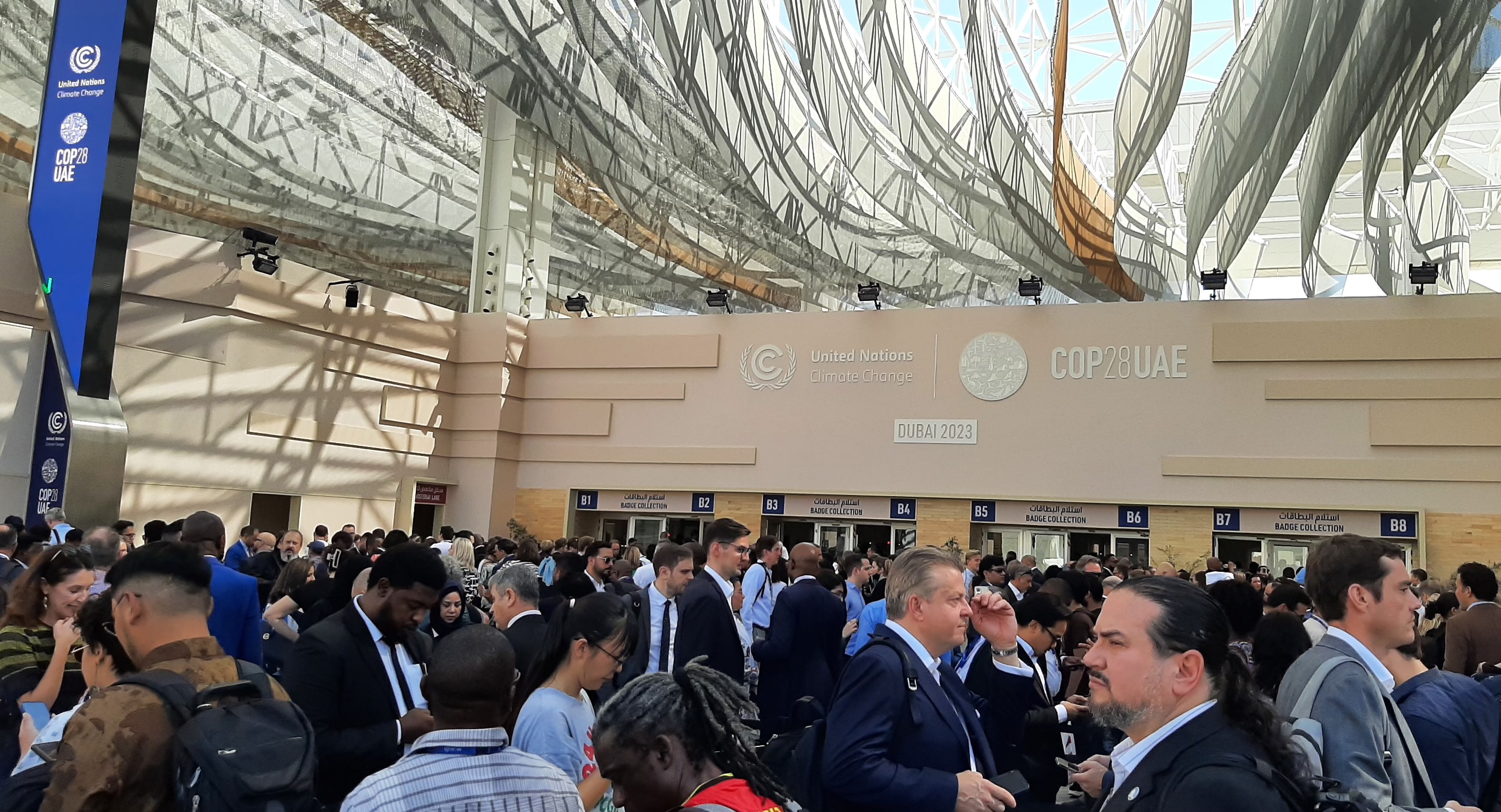 Delegates to COP28 Blue Zone queue for passes at the entrance to the Dubai exhibition centre
