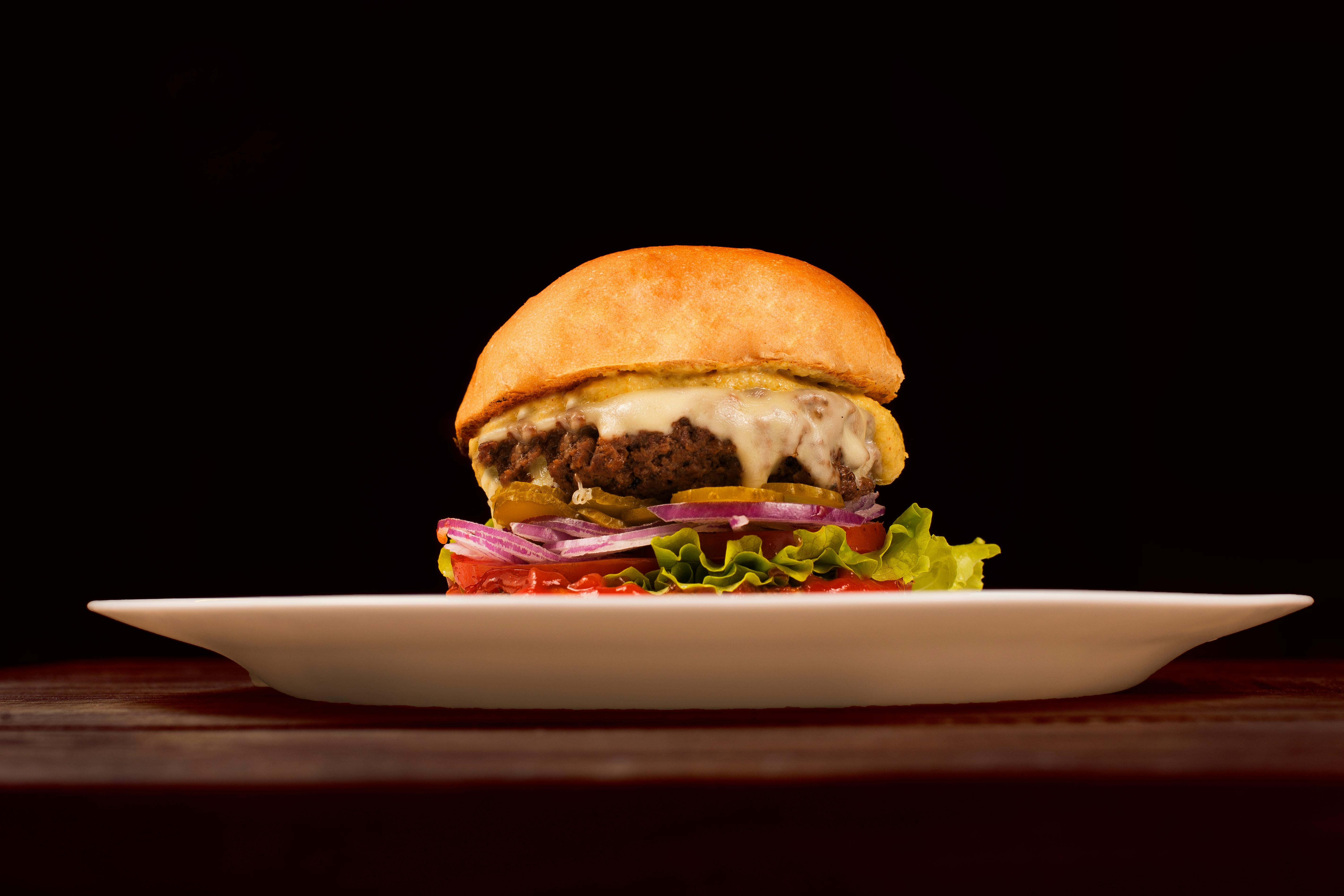 Photo of a burger on a plate. Credit: Daniel Reche via pexels