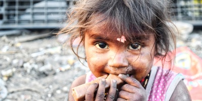 Image of an Indian child eating a chocolate bar. Photo by billycm via Pixaby