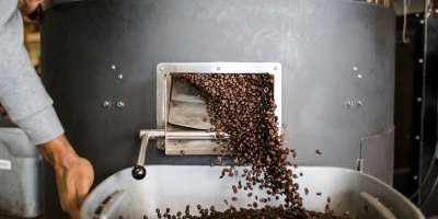 Photo of Coffee Beans being processed by a machine. Photo by Andrew Neel via Unsplash