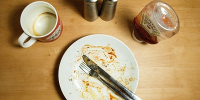 Photo of a finished plate of food and an empty mug. Photo by Richard Bell via Unsplash 