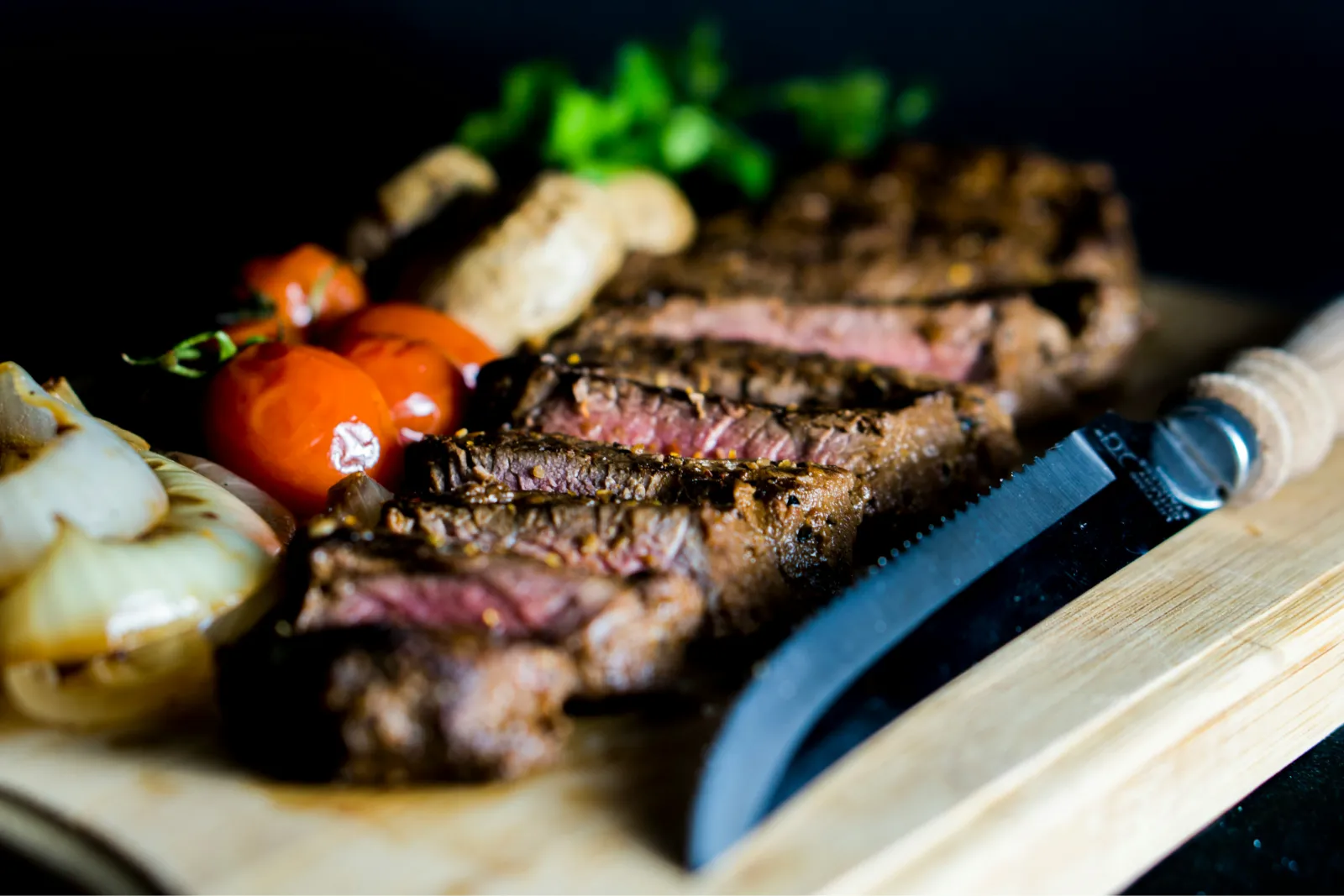 A steak and vegetables on a cutting board. Photo by Amirali Mirhashemian via Unsplash.
