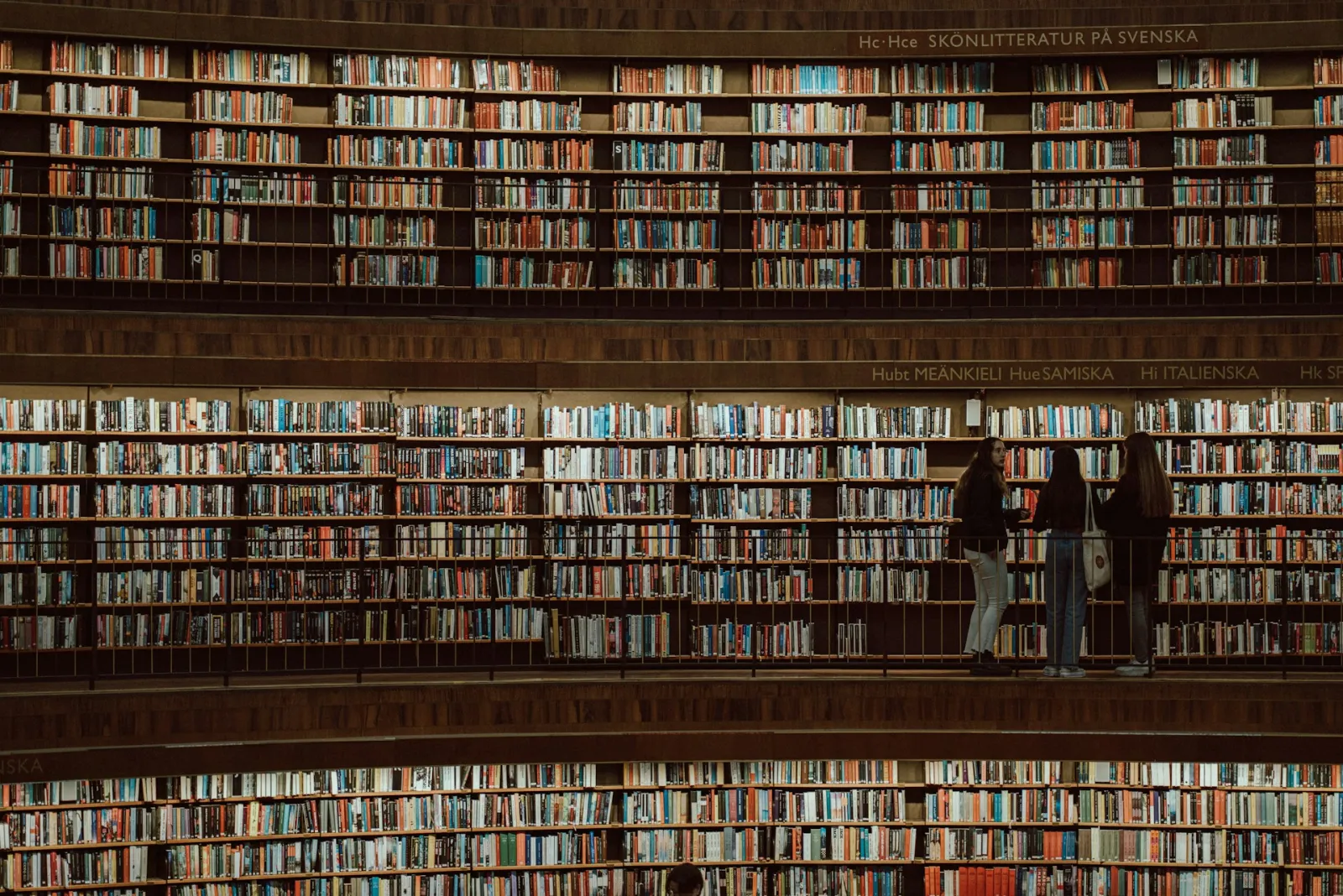 Visitors explore the multi-storey shelves of the Stockholm Public Library. Photo by Marcel Strauß via Unsplash. 