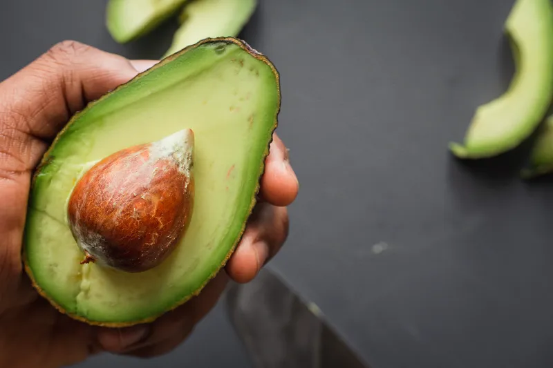 Image: Louis Hansel, person holding green and brown sliced fruit, Unsplash, Unsplash Licence