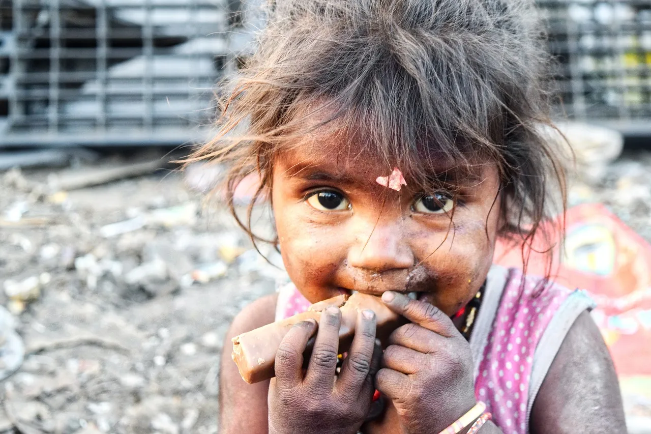 Image of an Indian child eating a chocolate bar. Photo by billycm via Pixaby
