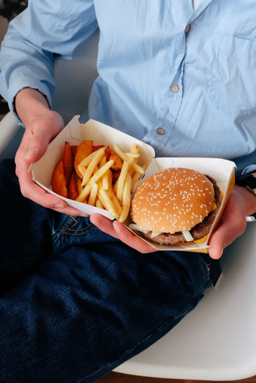 Photo of a burger and chips in single use packaging. Photo by ready made via Pexels.