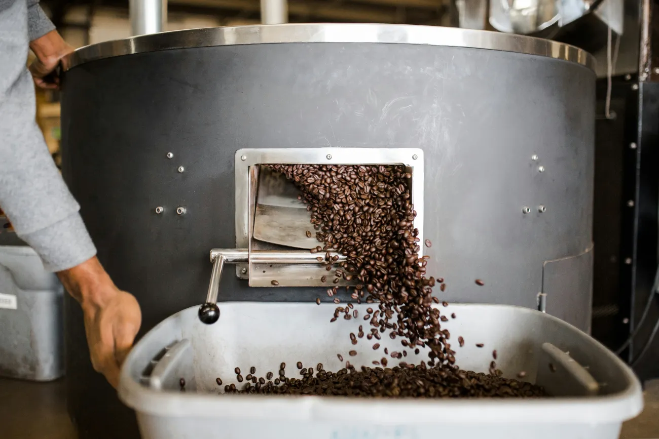 Photo of Coffee Beans being processed by a machine. Photo by Andrew Neel via Unsplash