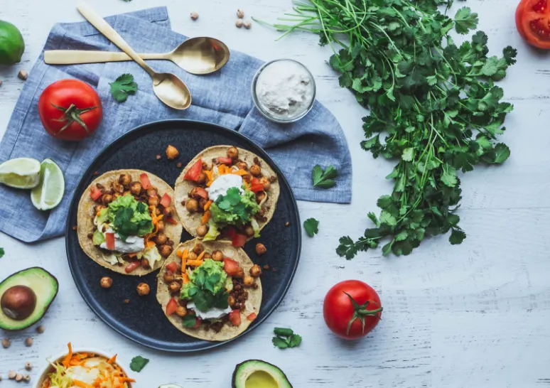Image of three vegan tacos and other fresh ingredients. Photo by shanriley via Unsplash 