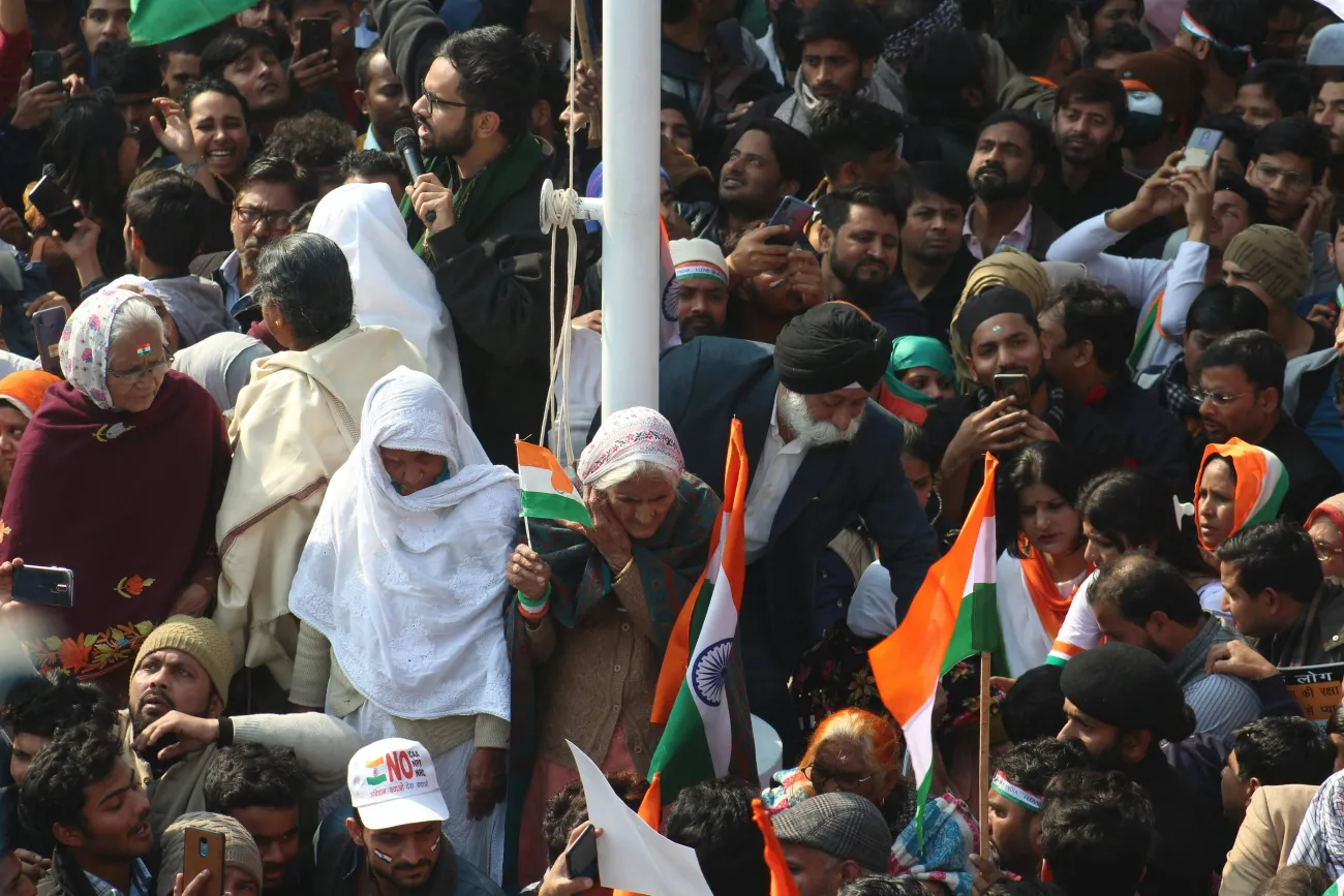 Image: Protester’s surrounding a pole holding Indian flags. Photo by Shakeb Tawheed via Pexels