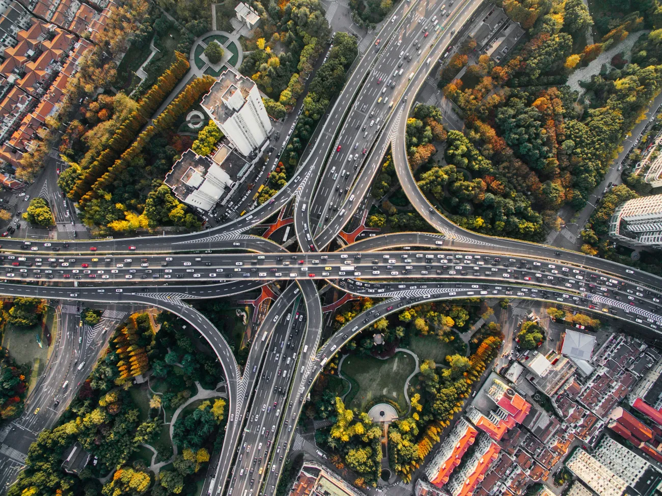 Highways crossing over an urban park. Photo by Denys Nevozhai via Unsplash.