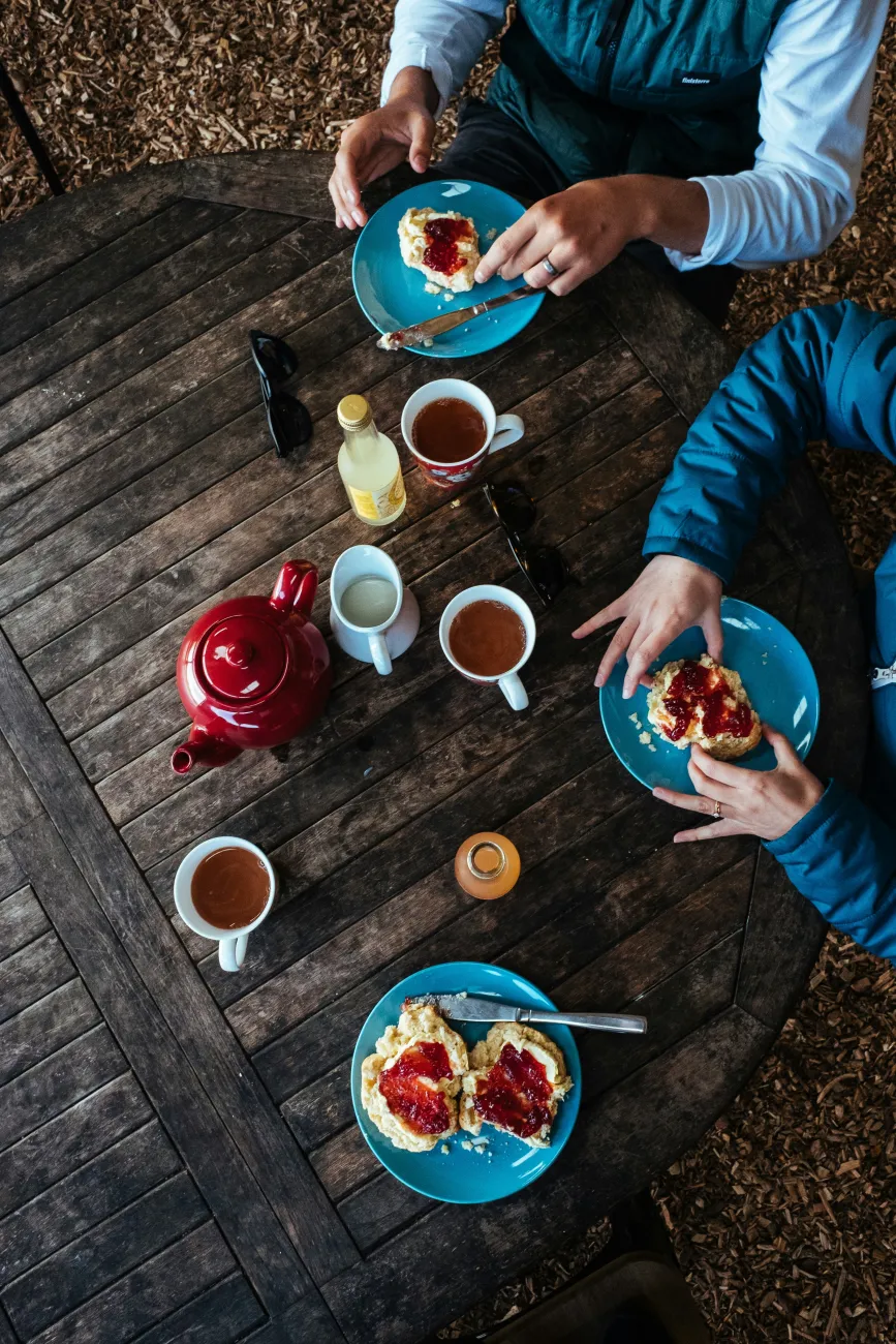 Tea and biscuits on a wooden table. Photo by Robert Bye via Unsplash.
