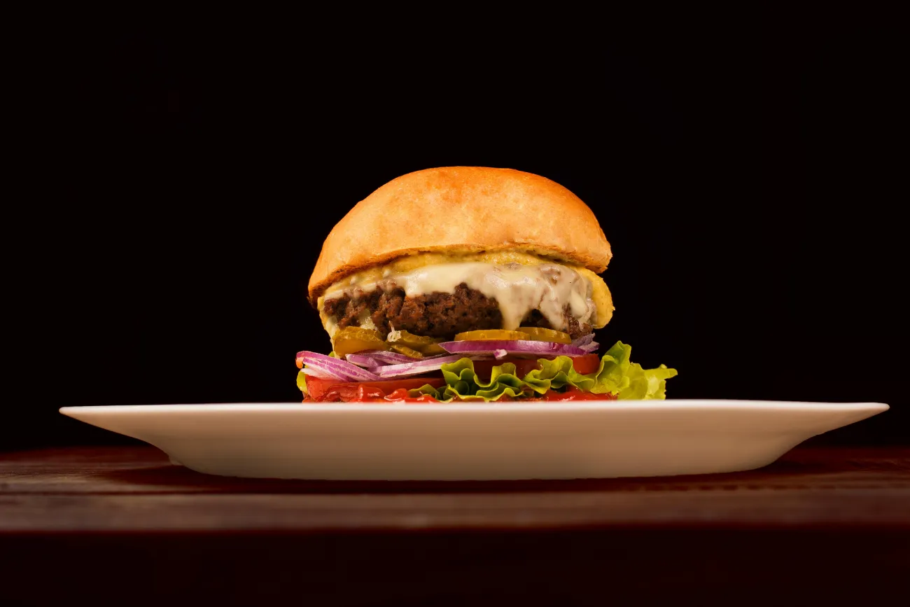 Photo of a burger on a plate. Credit: Daniel Reche via pexels