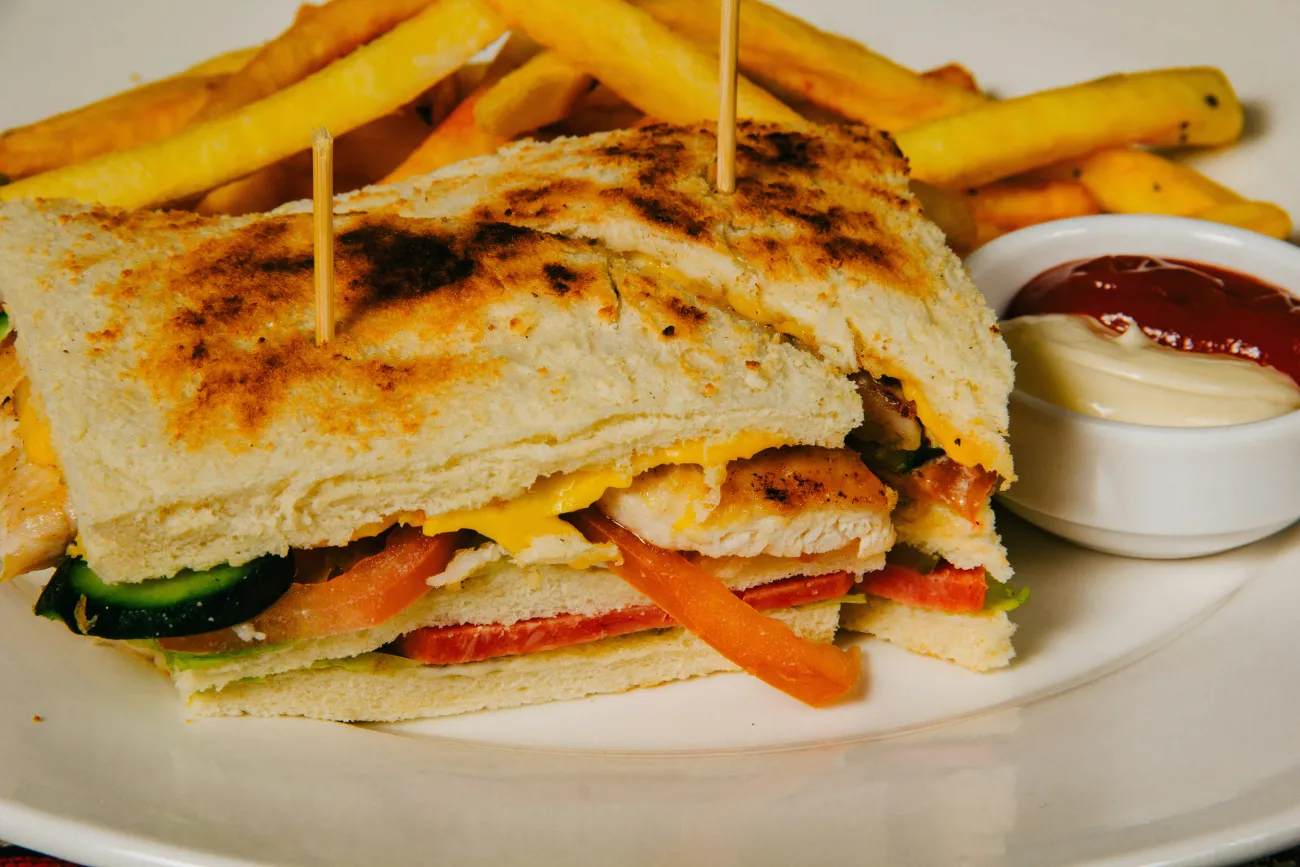 A greasy sandwich and fries. Photo by Ulvi Safari via Unsplash.