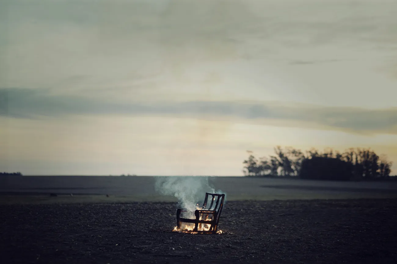 Burning chair in field. Credit: Carolina Basi via Pexels