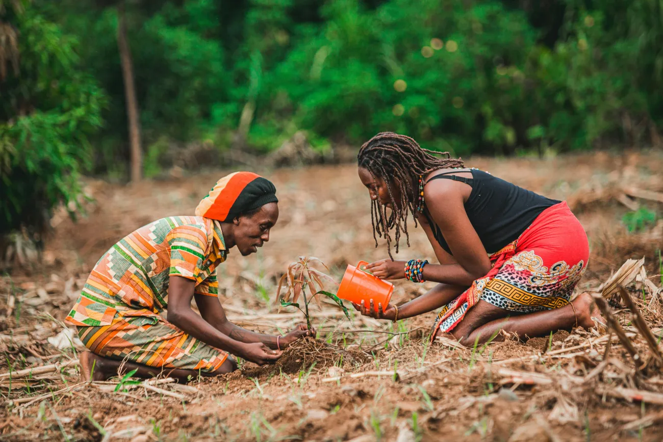women farming in Africa, holding soil. Credit: Safari Consoler via Pexels
