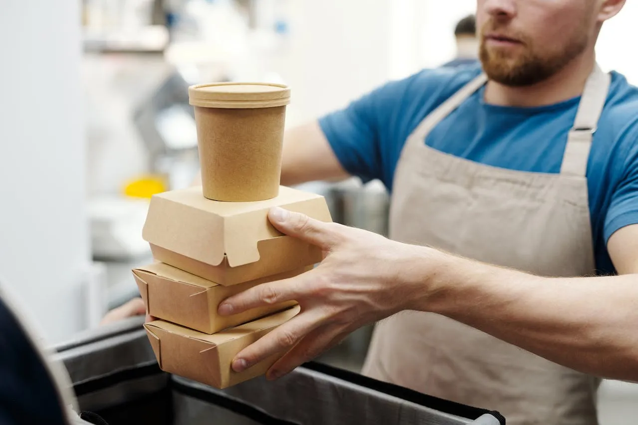 Man with food packaging. Credit: Norma Mortenson via Pexels