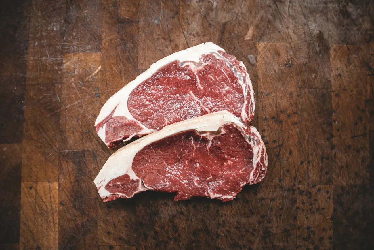 Photo of two pieces of sirloin on a wooden cutting board. Photo by Kyle Mackie via Unsplash.