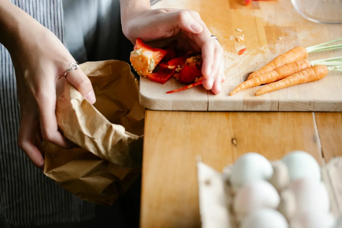 Food waste being pushed into paper bag. Credit: Sarah Chai via Pexels