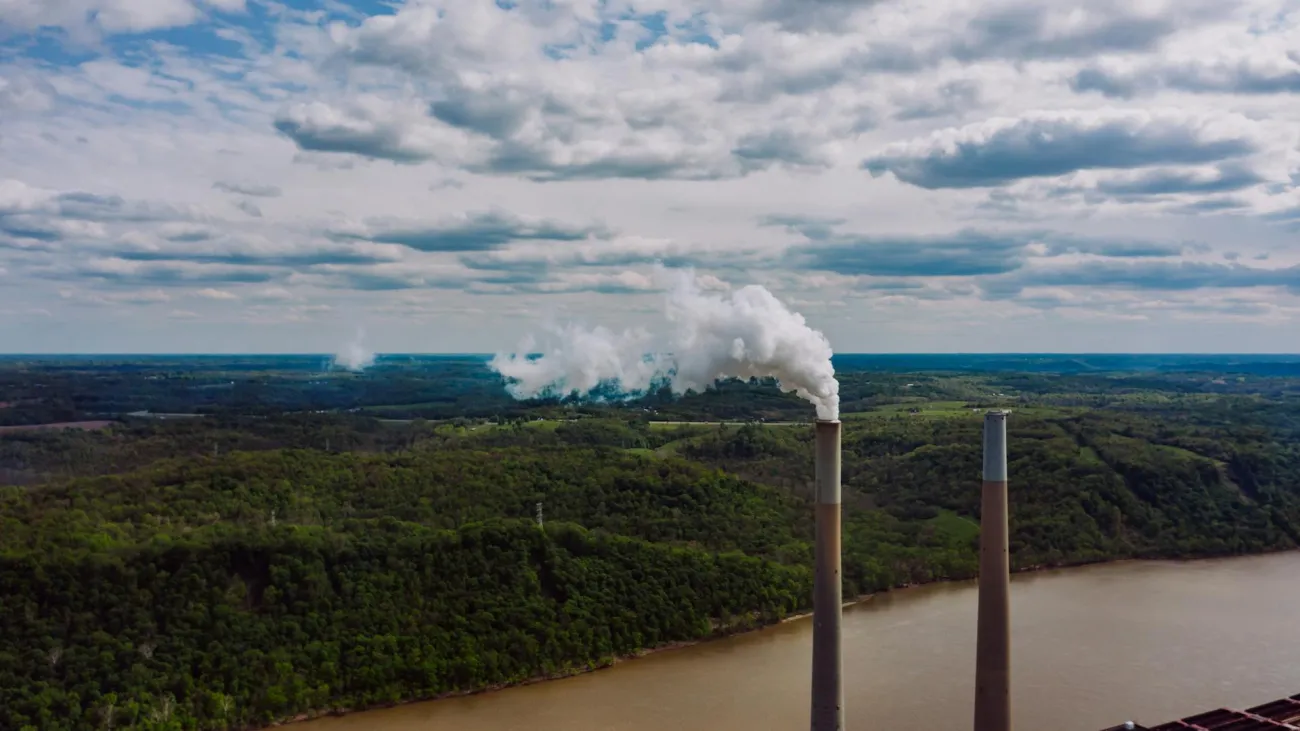 Steam coming out of chimney, forest in background. Credit: Kelly via Pexels