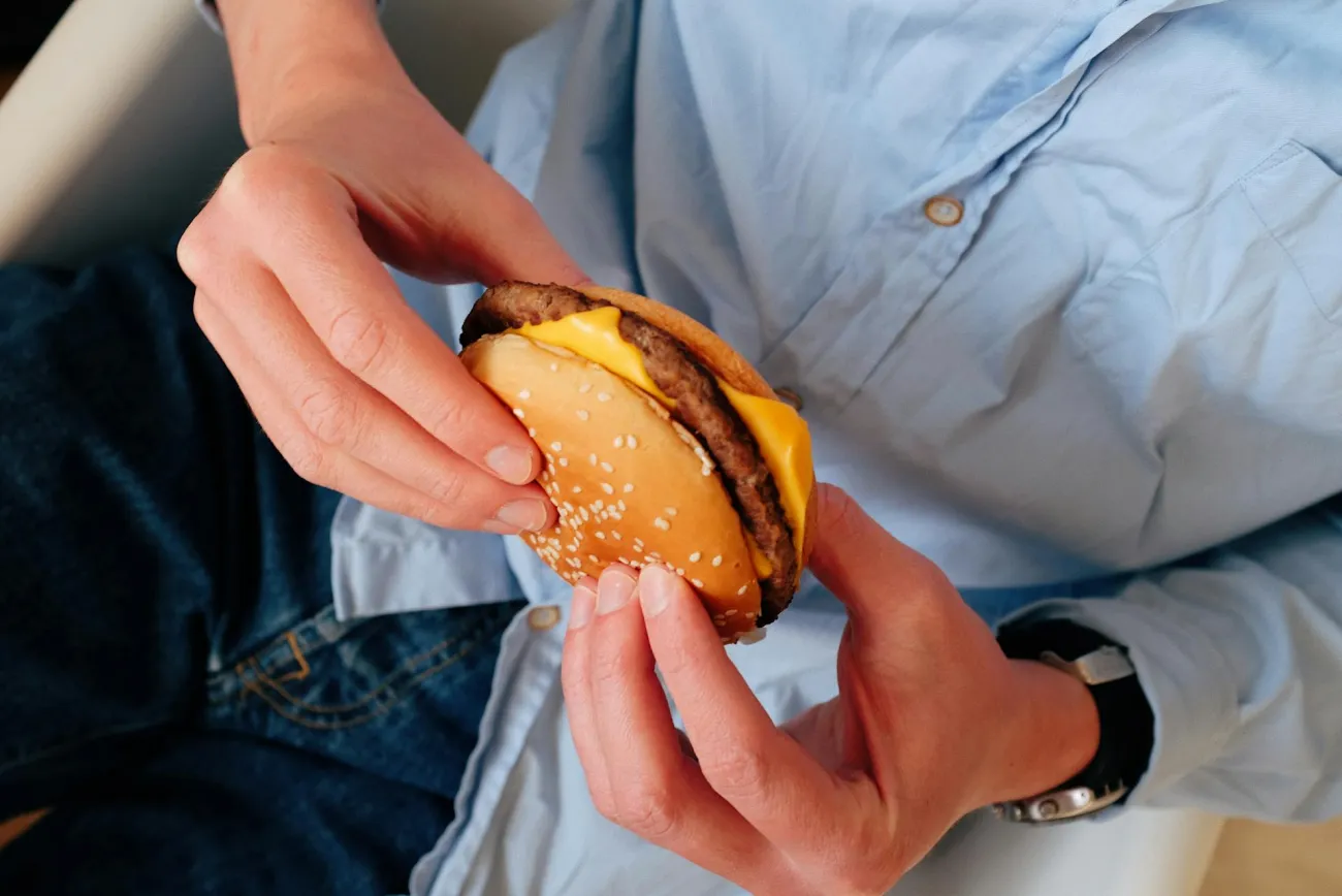 Man eating burger. Credit: ready made via Pexels. 