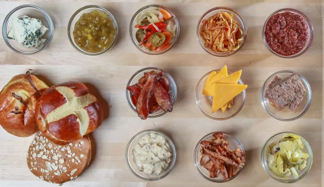 Charcuterie plate with mustards, cheeses, fruits, relishes, bacon, and breads. Tim Toomey via Unsplash.