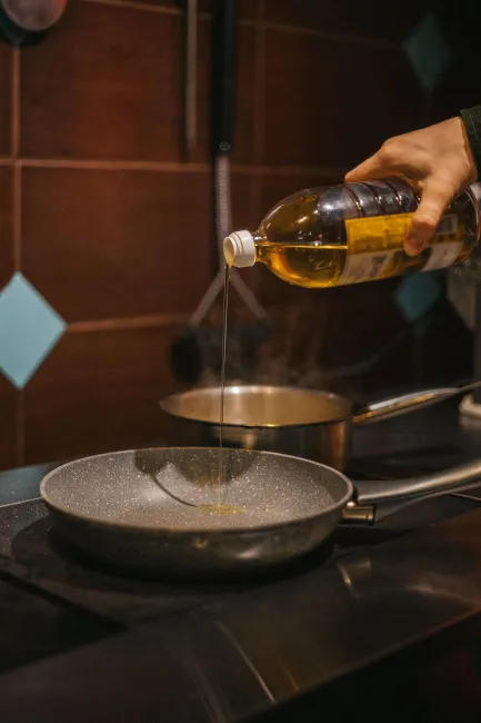 Photo of cooking oil being poured into a pan. Image by Max Avans via Pexels