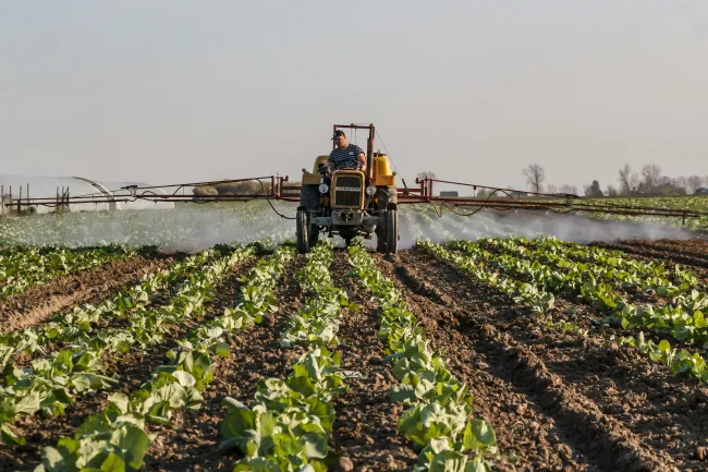 Photo of tractor with sprayer in field. Credit Stitch via Pexels