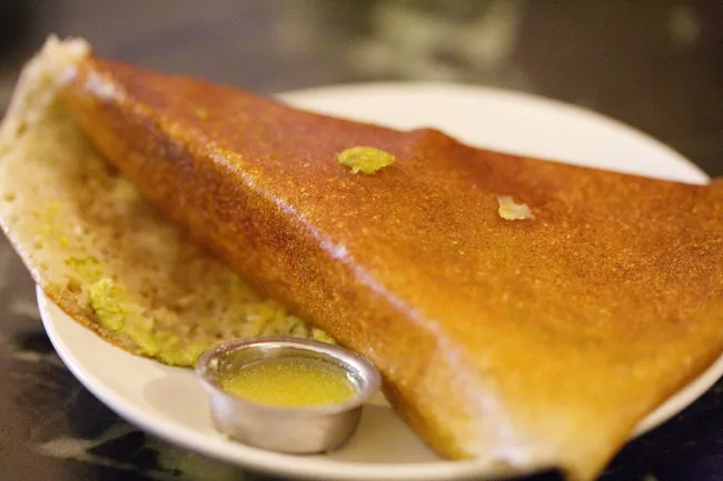 Image: Charles Haynes, Dosa (rice pancake) with a cup of ghee (clarified butter) at Mavalli Tiffin Room in Bangalore, Wikimedia Commons, Creative Commons Attribution-Share Alike 2.0 Generic Image: Charles Haynes, Dosa (rice pancake) with a cup of ghee (clarified butter) at Mavalli Tiffin Room in Bangalore, Wikimedia Commons, Creative Commons Attribution-Share Alike 2.0 Generic